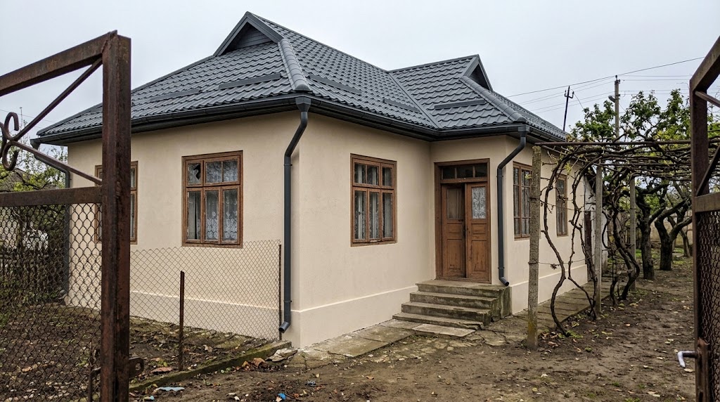 Aceeași casă după lucrări, cu acoperiș nou închis la culoare și fațadă refăcută