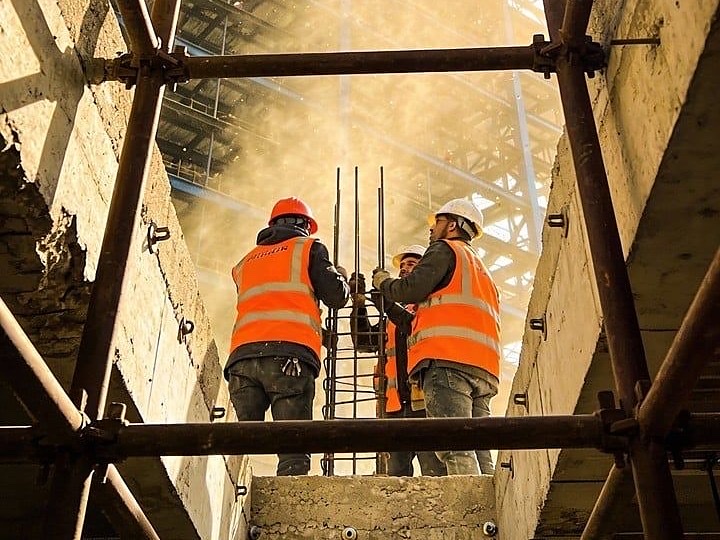 Armătură de stâlp în lucru, echipă pe schelă într-o clădire în construcție