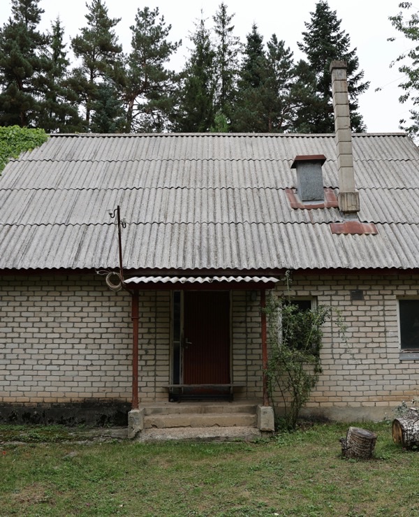 Casă din cărămidă cu acoperiș vechi din ardezie ondulată